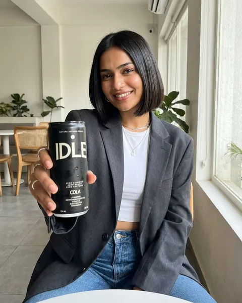 Concept visual: a person holding IDLE IDLE Cola